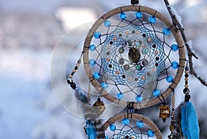 Close up of dreamcatcher with owl and blue feathers.