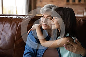 Close up dreamy mature woman and little girl hugging