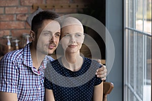 Close up dreamy sick hairless woman and man hugging, dreaming