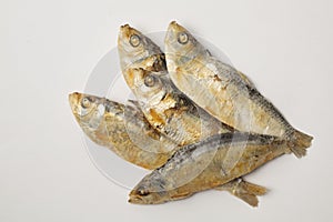 Close up of dried herrings against a white backgound.