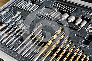 Different lengths of drilling machine bits on wooden background