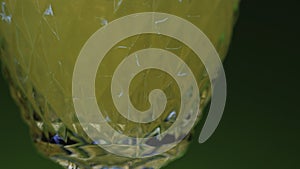 Close-up of drink being poured into transparent glass. Stock clip. Green alcoholic drink is poured into glass. Club