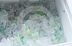 Close up on drinking cans inside ice blocks in the cooler