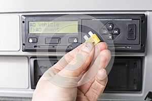 Close up of a driver holding a fuse. Speed limiter disabled by pulling a fuse out. Transportation concept