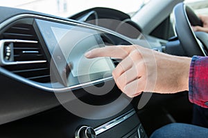 Close Up Of Driver Using Touchscreen In Car