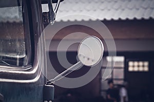 Close-up of a driving mirror on a vintage vehicle.old warehouse blur background