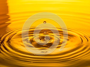 Close up of a drop oil on a yellow background