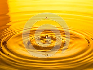 Close up of a drop oil on a yellow background