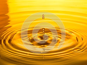 Close up of a drop oil on a yellow background