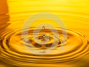 Close up of a drop oil on a yellow background