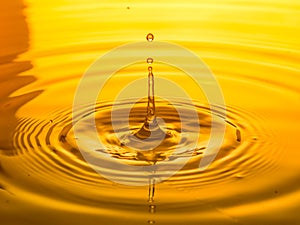 Close up of a drop oil on a yellow background