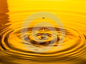 Close up of a drop oil on a yellow background