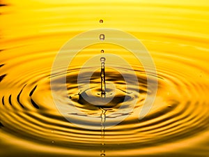 Close up of a drop oil on a yellow background