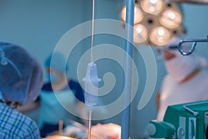 Close-up of dropper dispenser in the operating room. Against the backdrop of a defocused team of children`s surgeons, work in the