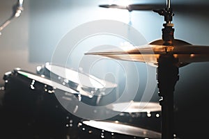 Close-up Drum set in a dark room against the backdrop of the spotlight. Atmospheric background symbol of playing rock or