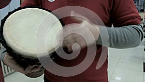 Close-up of a drummer's hand. Ethnic music in a modern building interior. Real sound and rhythm. Percussion musical instrument, wh