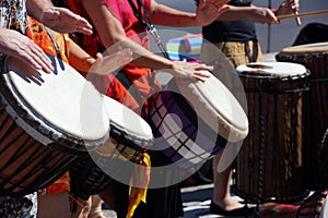 Close up of drumming by woman in bright clothes,