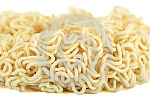 Close-up of dry instant noodles on a white background. Focus on the foreground, background blurred.