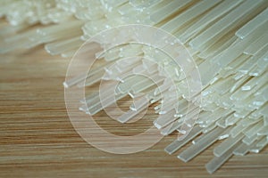 close-up dry rice sticks noodle, authentic thai cuisine on wooden table background