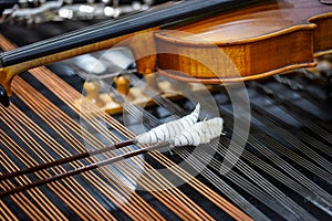 Close up of dulcimer strings and drumsticks with lying violins