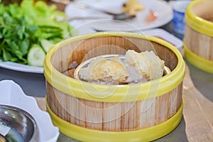 Close up dumpling Dim sum in the steam basket. Delicious chinese snack. Steaming minced pork with jelly fish on restaurant