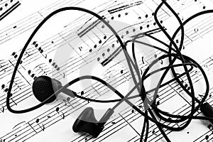 Close up of ear buds and sheet music