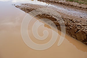 Close-up of earthy and muddy puddle on wet dirt road