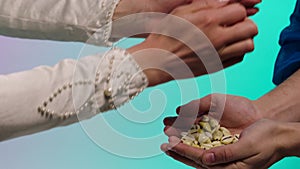 Close up for eastern young woman hands giving many small seashells to man hands, barter concept. Stock. Eastern woman in