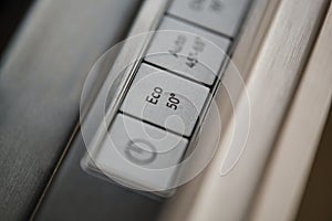 Close-up of eco button in a modern dishwasher control panel.