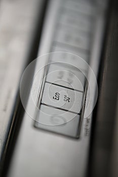 Close-up of eco button in a modern dishwasher control panel.