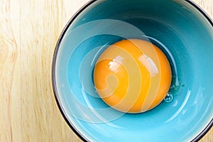 Close up egg yolk in bowl on wooden table