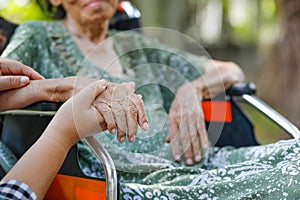 Elderly asian woman on wheelchair at home with daughter take care photo