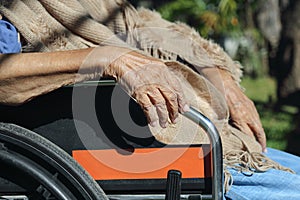 Più vecchio mani sul sedia rotelle 