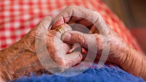 Close up elderly hands of a widowed old woman holding rings. Caucasian grandma