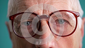 Close-up of elderly man grandfather taking off his glasses looking at camera