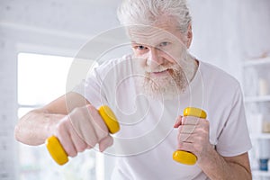 Close up of elderly man practicing boxing jabs with dumbbells