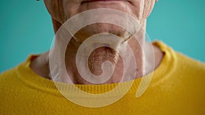 Close-up of an elderly man swallowing an Adam's apple, larynx and throat in the process of swallowing