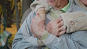 Close up elderly wrinkled hands mature retired couple married family grandpa man stroking woman wife hand embracing