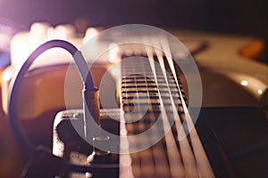 A close up of an electric guitar on a dark background