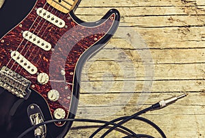 Close-up of electric guitar lying on vintage wood background, with copy space