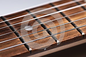 close-up of an electric guitar neck with wood frets and strings. Music background