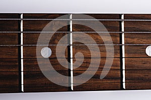 close-up of an electric guitar neck with wood frets and strings. Music background