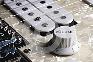 Close-up of electric guitar pickups and volume knob