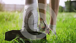 Close-up of an electric lawn trimmer in action