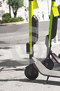 Close up of a electric scooters, parked on the street; with copy space