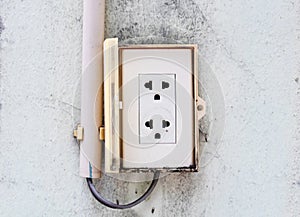Close Up electrical power socket and plug socket on old concrete wall cream color.