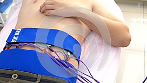 Close-up. electrical stimulation procedure for abdominal muscles. a man passively stimulates the abdominal muscles.