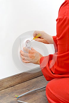 Close up of electrician hands fixing socket