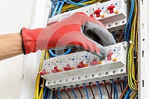 Close up of electrician\'s hands in working gloves installing and maintainin electrical junction box