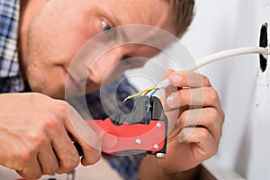 Close-up of electrician stripping wires photo